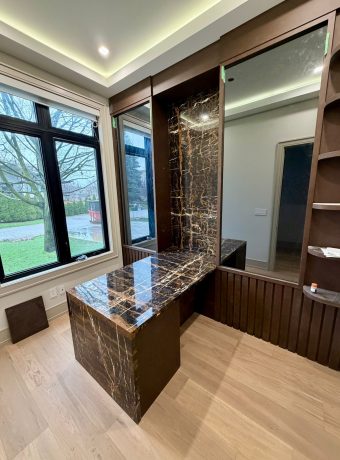 Custom marble feature wall with matching stone vanity and modern built-in shelving, fabricated and installed by ECCO Stone Works in Toronto GTA.